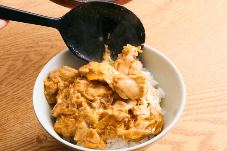 ごはんの上に、お玉などで出来上がった親子丼をそっとすくってのせる